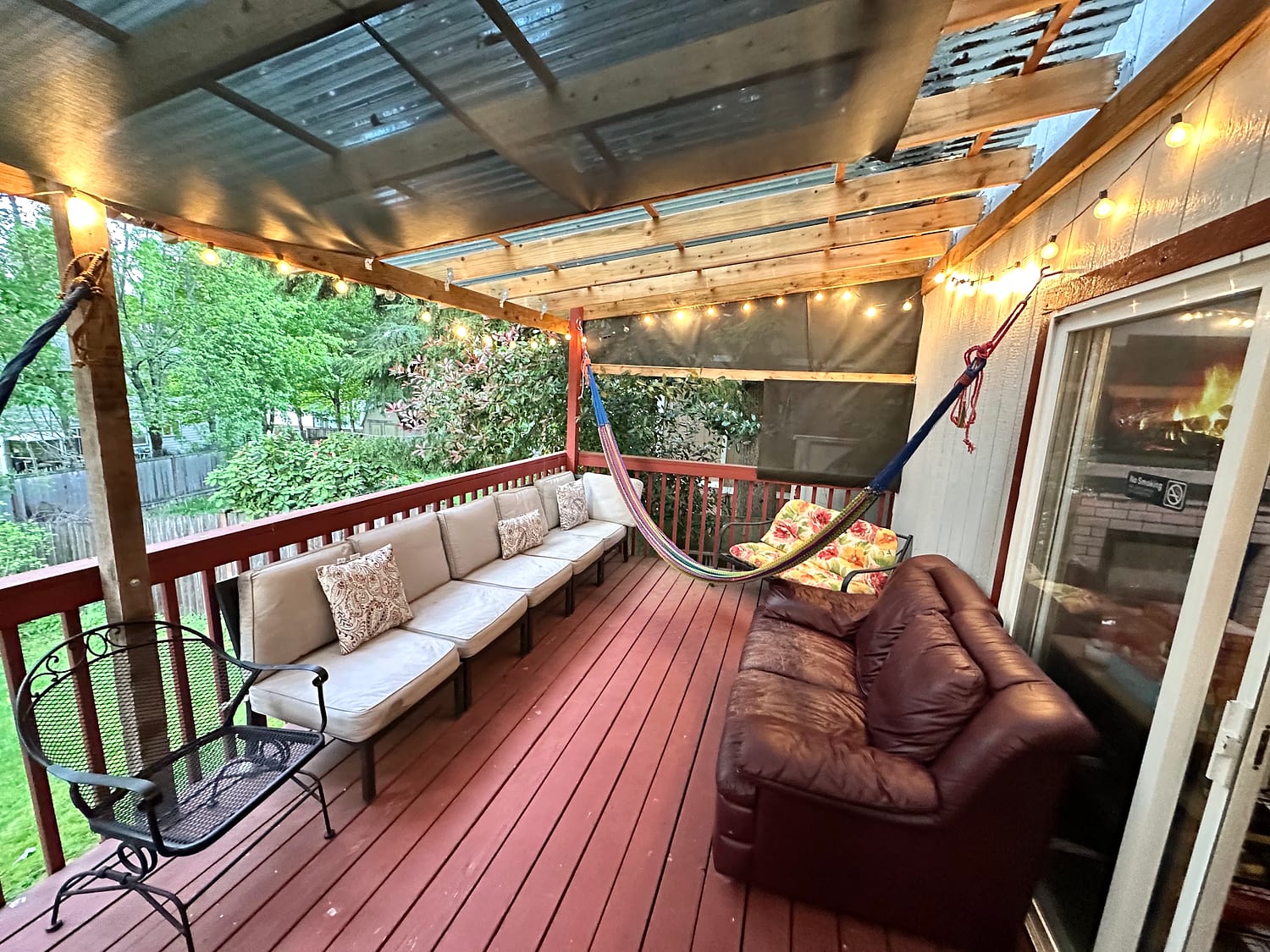 The covered deck at JOY-Graham with comfortable seating and string lights.
