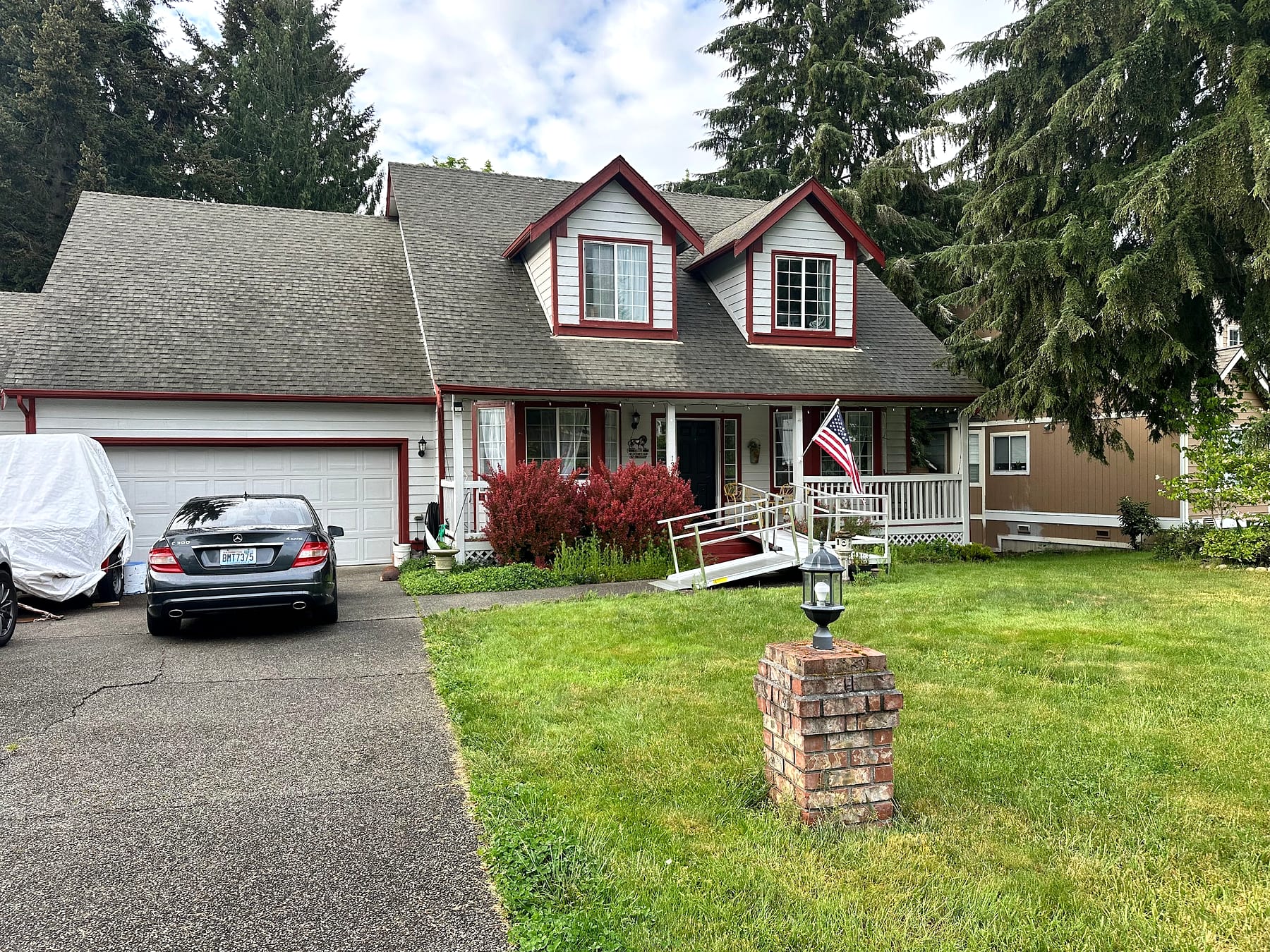 Daytime front view of the JOY-Graham home with porch and accessibility ramp.