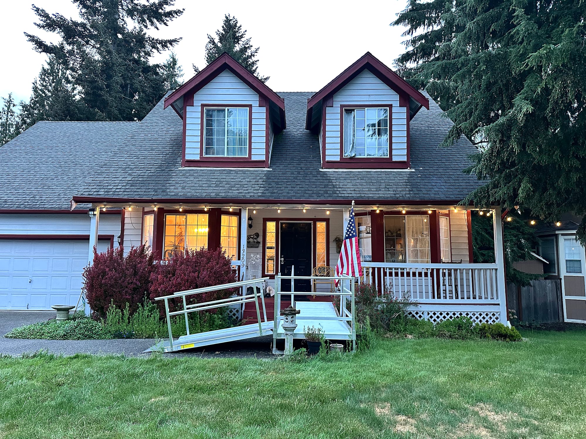 JOY-Graham home at dusk with glowing windows and porch lights.